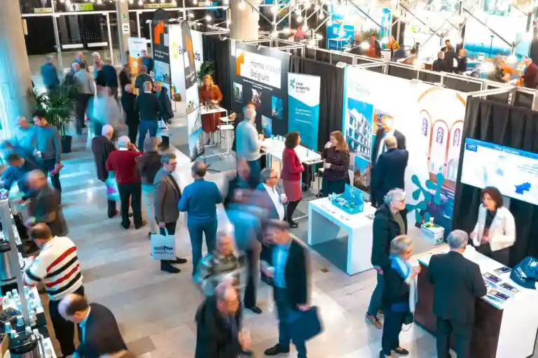 Bezoekers aan de stand van Care Property Invest tijdens een informatie-event voor investeerders