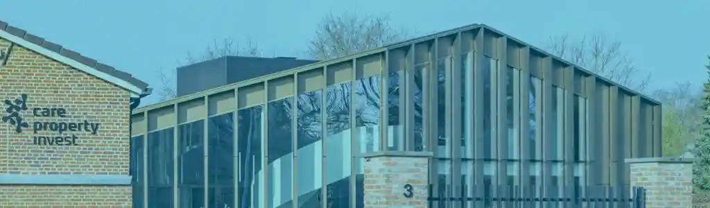 Het kantoorgebouw van Care Property Invest met bakstenen gevel en glaspartij